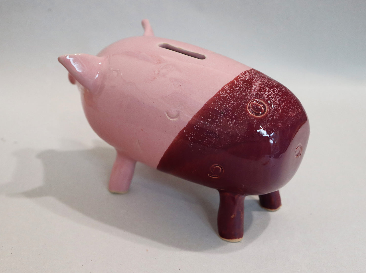 Original Keramik - Sparschwein von Anette Weber, seitliche Ansicht links, Farbe rosa und weinrot,  erhältlich bei Galerie Waldbach - What The Artist Made