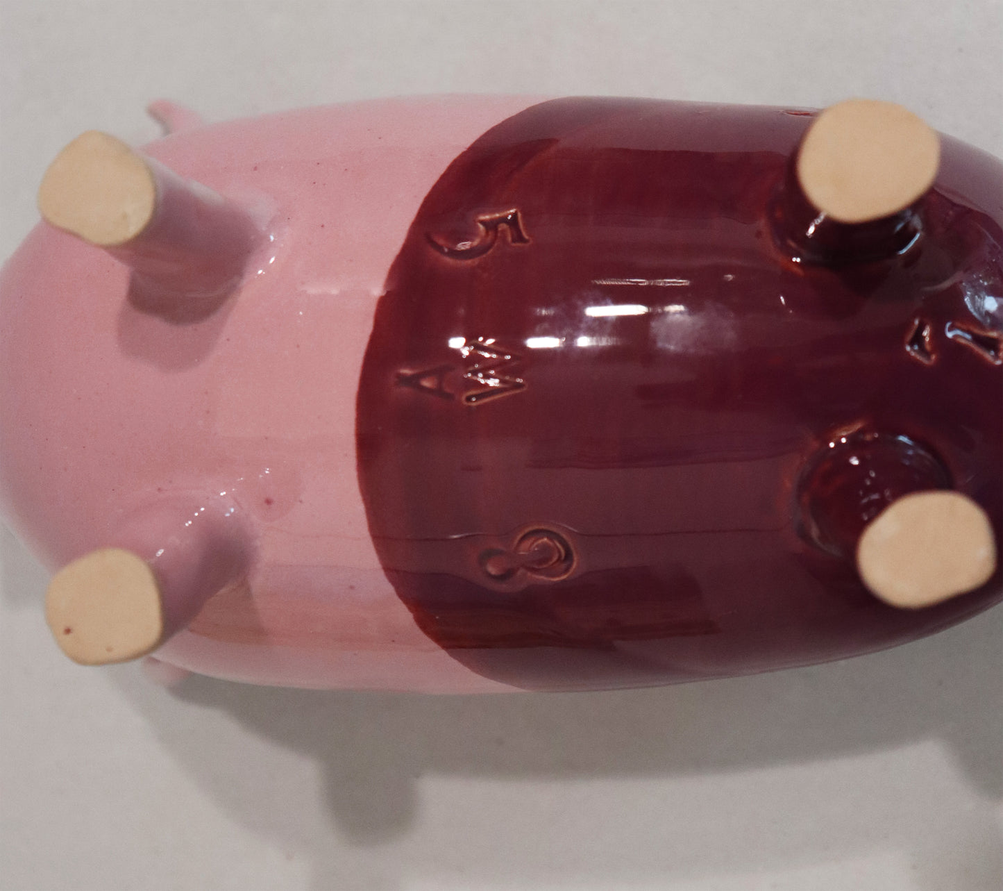 Original Keramik - Sparschwein von Anette Weber, Unterseite mit Signaturstempel "AW",  Farbe rosa und weinrot, erhältlich bei Galerie Waldbach - What The Artist Made