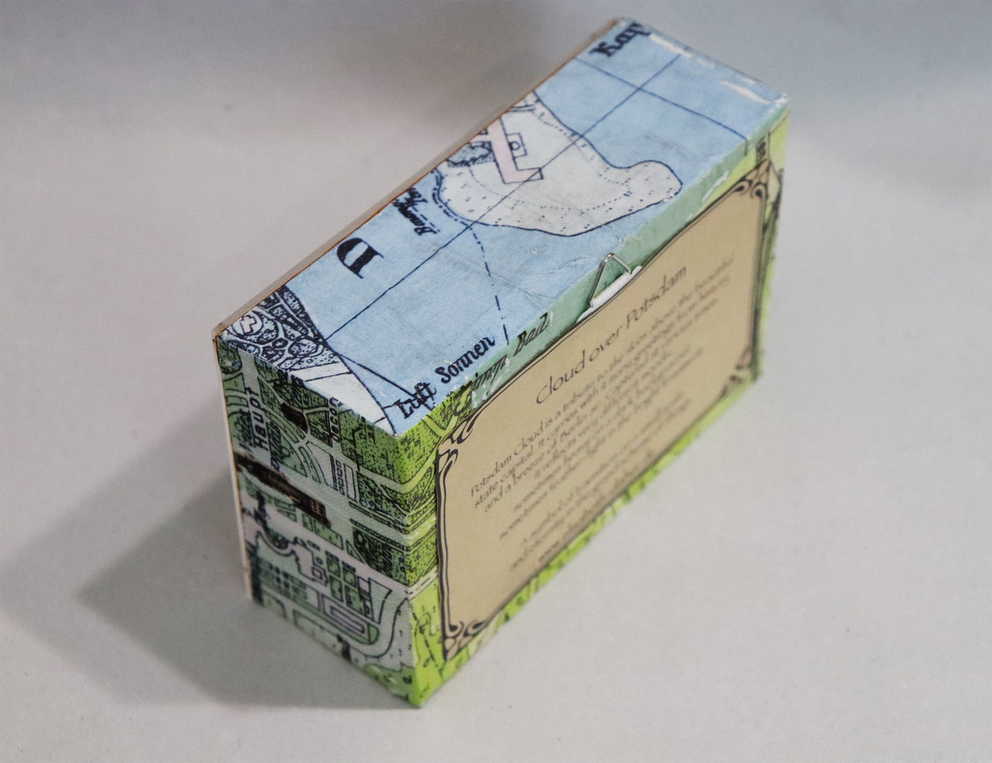 Original Objekt - Assemblage von Elisabeth Dishur, Titel „Clouds over Potsdam" – Objektkiste. Seitliche Ansicht, rechte Seite: Papiercollage mit Stadtkarte von Potsdam umfassend auf der Kiste.  Objektcollage, erhältlich bei Galerie Waldbach - What The Artist Made