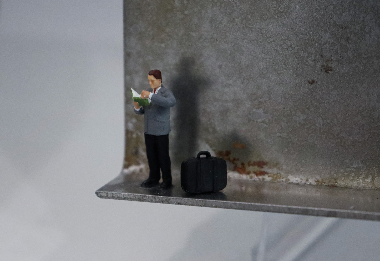 Original Objekt - Assemblage von Katrin Schramm, Titel „Bücher sind Lebensmittel“ – Metallwinkel mit Miniatur-Figur, Detailansicht. Objektcollage, erhältlich bei Galerie Waldbach - What The Artist Made