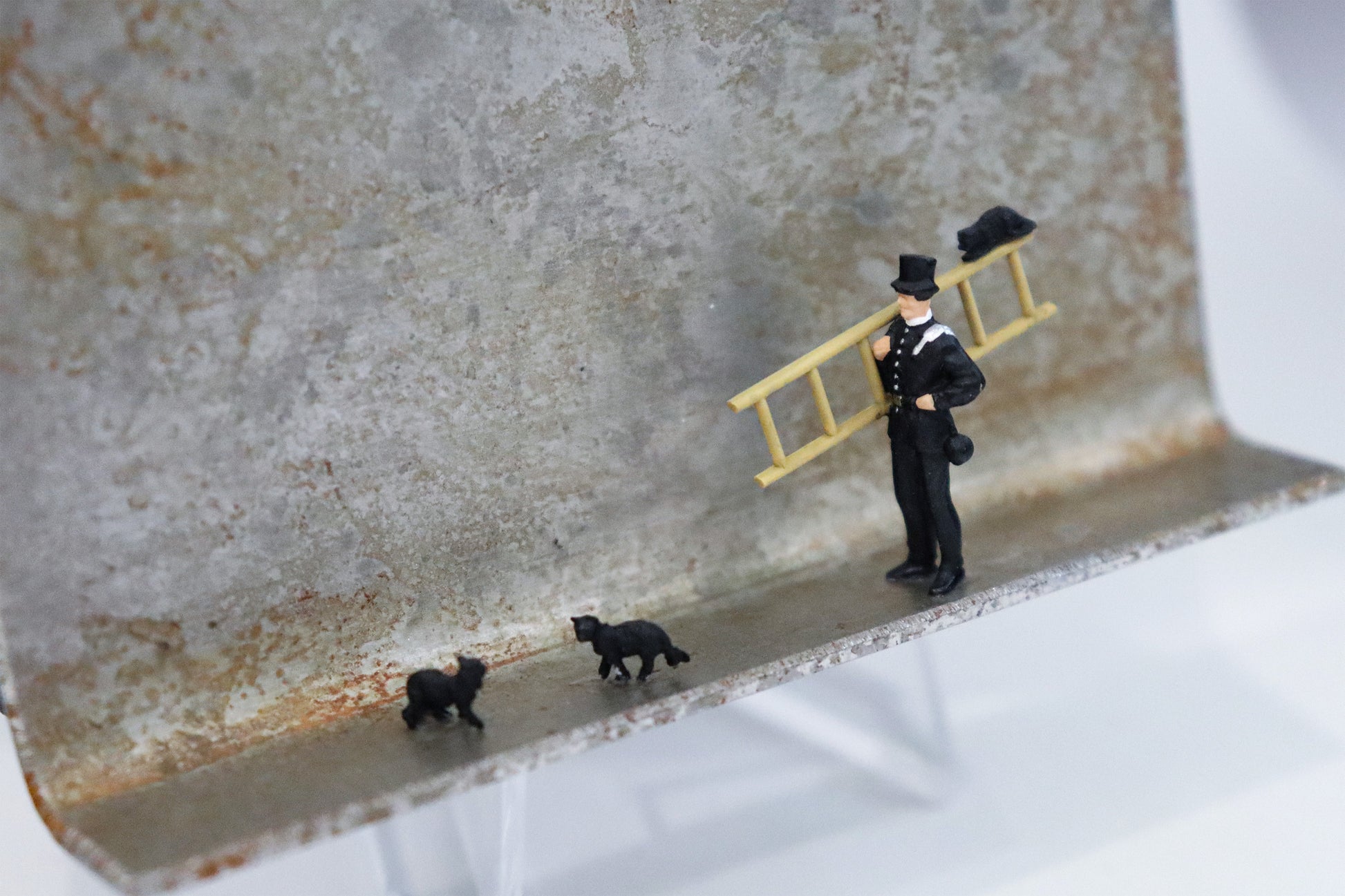 Original Objekt - Assemblage von Katrin Schramm, Titel „Das Glück ist schwarz.“ – Metallwinkel mit Miniatur-Figuren, Detailansicht. Objektcollage, erhältlich bei Galerie Waldbach - What The Artist Made
