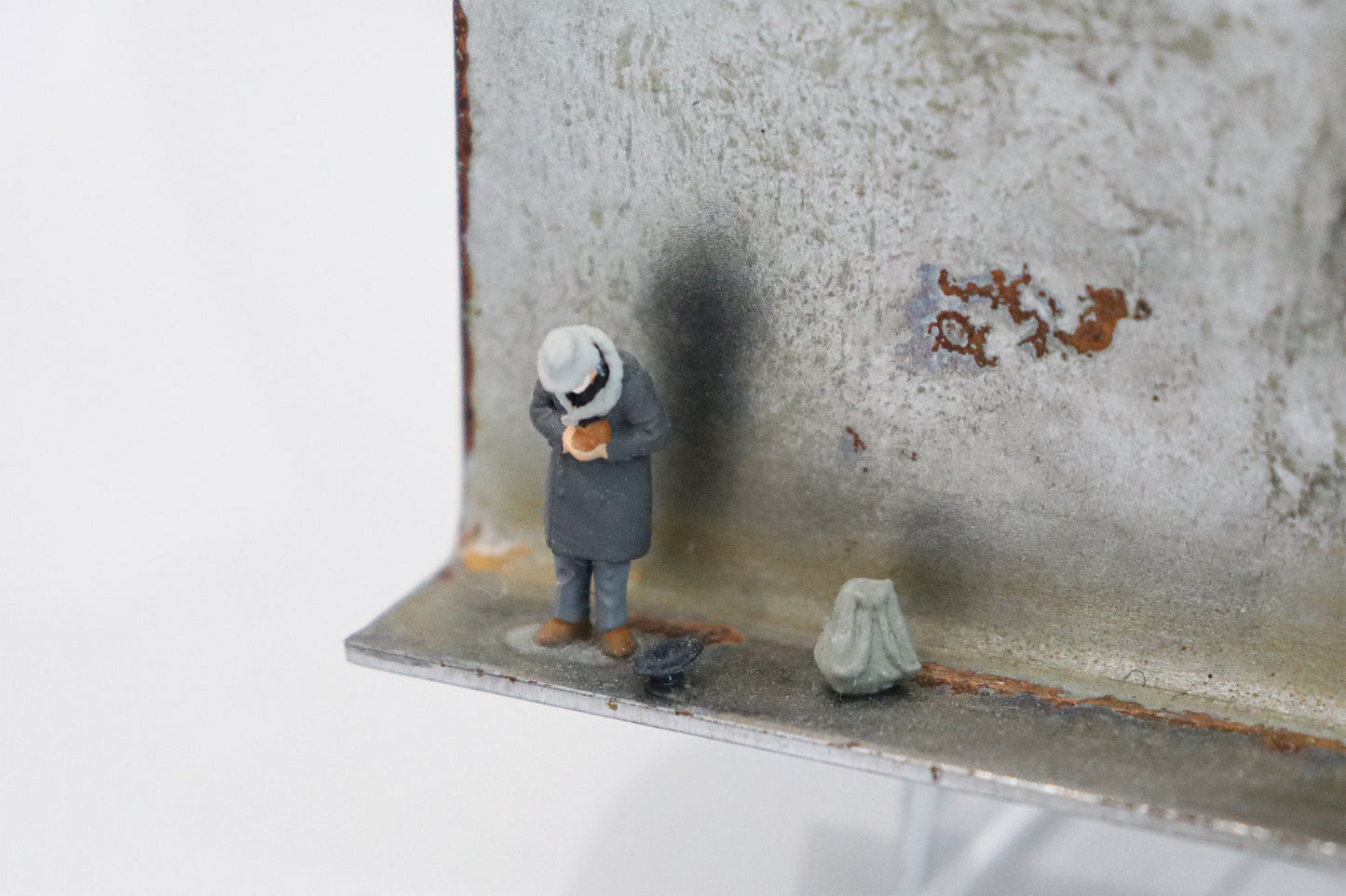 Original Objekt - Assemblage von Katrin Schramm, Titel „Geben...“ – Metallwinkel mit Miniatur-Figur:, Detailansicht.  Objektcollage, erhältlich bei Galerie Waldbach - What The Artist Made