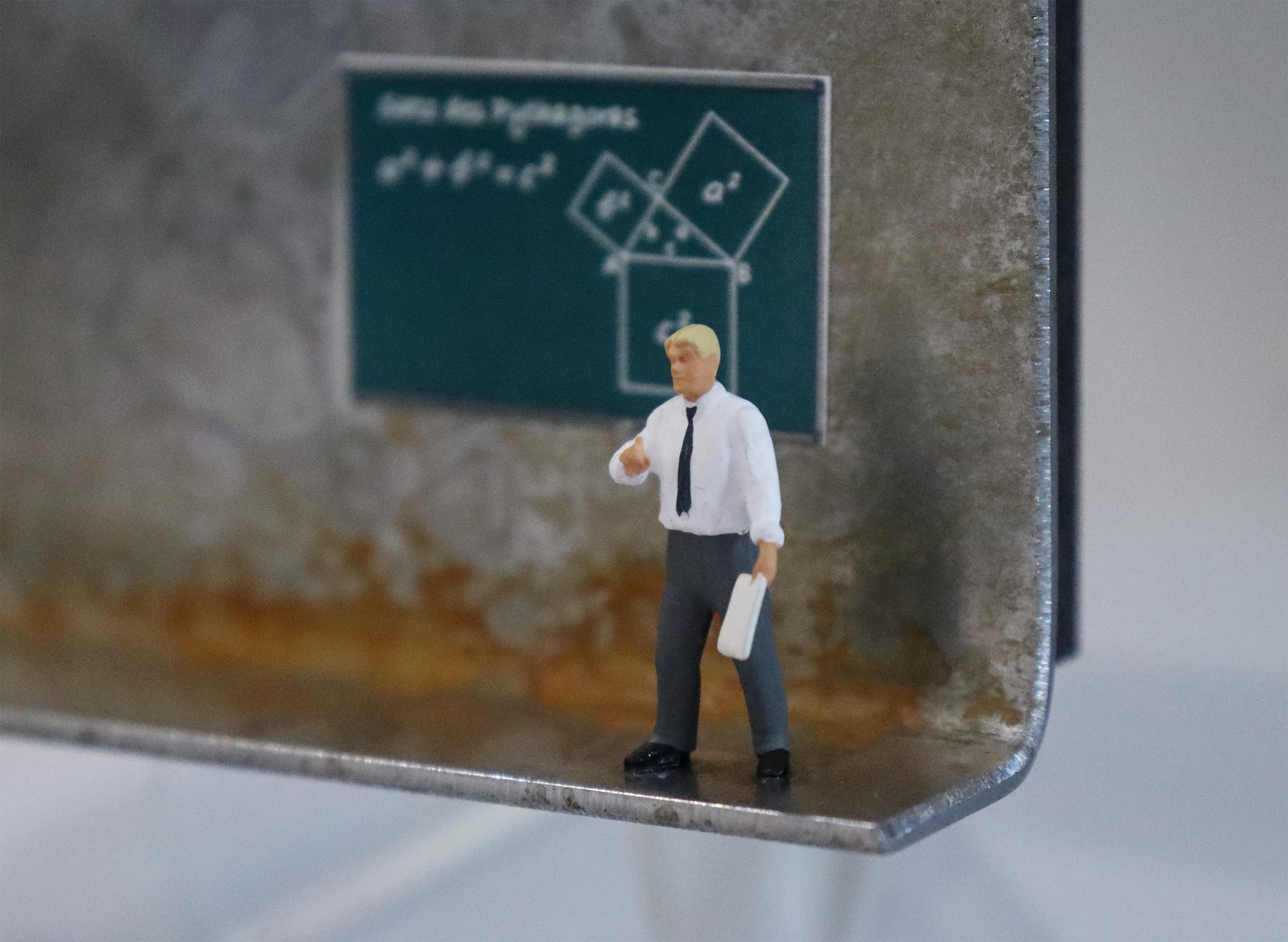 Original Objekt - Assemblage von Katrin Schramm, Titel „Die Zahl ist das Wesen aller Dinge.“  – Metallwinkel mit Miniatur-Figur, Detailansicht. Objektcollage, erhältlich bei Galerie Waldbach - What The Artist Made