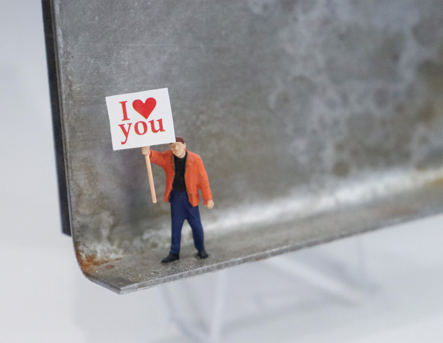 Original Objekt - Assemblage von Katrin Schramm, Titel „Einfach so!“  – Metallwinkel mit Miniatur-Figur, Detailansicht. Objektcollage, erhältlich bei Galerie Waldbach - What The Artist Made