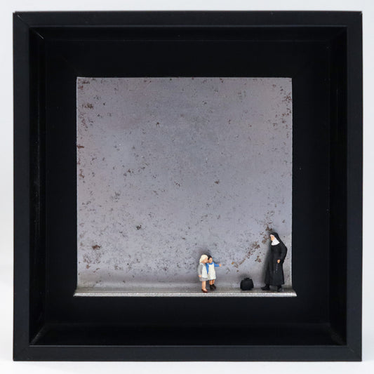 Original Objekt - Assemblage von Katrin Schramm, Titel „Jedes Kind ist kostbar.“ – Metallwinkel mit Miniatur-Figuren: Eine Nonne steht am rechten Rand des Winkels. Vor  ihr eine schwarze Reisetasche. Davor stehen zwei Kinder, ihr zugewandt. Dahinter das Metall des Winkels mit Struktur, als Hintergrund. Objektcollage im schwarzen Rahmen, erhältlich bei Galerie Waldbach - What The Artist Made