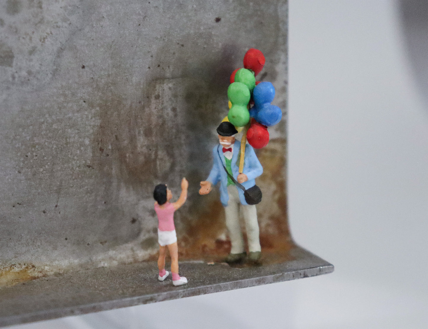 Original Objekt - Assemblage von Katrin Schramm, Titel „Lass sie fliegen!“  – Metallwinkel mit Miniatur-Figuren, Detailansicht. Objektcollage, erhältlich bei Galerie Waldbach - What The Artist Made