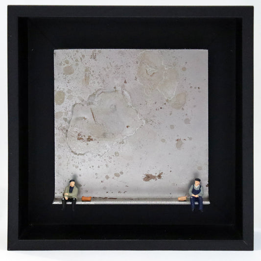 Original Objekt - Assemblage von Katrin Schramm, Titel „Moin       Moin“ – Metallwinkel mit Miniatur-Figuren: Zwei Männer sitzen jeweils am Rand des Winkels. Beide tragen Arbeitskleidung und haben eine Tasche neben sich liegen. Sie schauen sich an. Dahinter das Metall des Winkels mit Struktur, als Hintergrund. Objektcollage im schwarzen Rahmen, erhältlich bei Galerie Waldbach - What The Artist Made