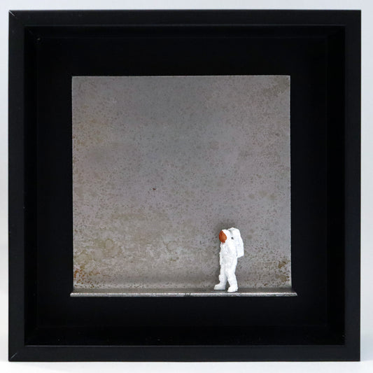 Original Objekt - Assemblage von Katrin Schramm, Titel „That's one  small step...“ – Metallwinkel mit Miniatur-Figur: Ein Astronaut steht am rechten Rand des Winkels und schaut zur gegenüberliegenden Seite. Dahinter das Metall des Winkels mit Struktur, als Hintergrund. Objektcollage im schwarzen Rahmen, erhältlich bei Galerie Waldbach - What The Artist Made