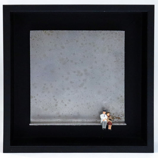 Original Objekt - Assemblage von Katrin Schramm, Titel „Wolke 9“ – Metallwinkel mit Miniatur-Figuren: Ein altes Paar sitzt am rechten Rand des Winkels und schaut in die Ferne. Dahinter das Metall des Winkels mit Struktur, als Hintergrund. Objektcollage im schwarzen Rahmen, erhältlich bei Galerie Waldbach - What The Artist Made