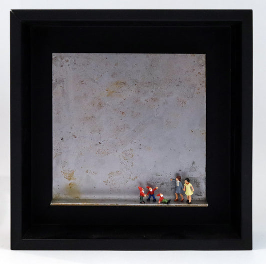 Original Objekt - Assemblage von Katrin Schramm, Titel „Zwergengeflüster.“ – Metallwinkel mit Miniatur-Figuren: Zwei Frauen/Mädchen stehen am rechten Rand des Winkels. Neben ihnen eine Gruppe aus drei Zwergen mit roten Mützen. Einer sitzt und schaut zu ihnen hoch, die beiden anderen stehen dahinter. Dahinter das Metall des Winkels mit Struktur, als Hintergrund. Objektcollage im schwarzen Rahmen, erhältlich bei Galerie Waldbach - What The Artist Made