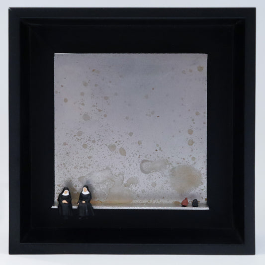 Original Objekt - Assemblage von Katrin Schramm, Titel „Ach Gott...“ – Metallwinkel mit Miniatur-Figuren: Zwei Nonnen sitzen am linken Rand des Winkels. Am rechten Rand stehen ihre Reisetaschen, eine braune und eine schwarze. Dahinter das Metall des Winkels mit Struktur, als Hintergrund. Objektcollage im schwarzen Rahmen, erhältlich bei Galerie Waldbach - What The Artist Made